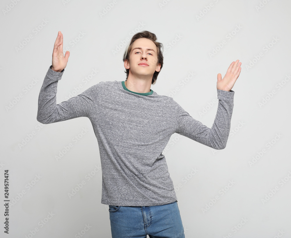 Fototapeta premium Happy young handsome man gesturing and keeping mouth