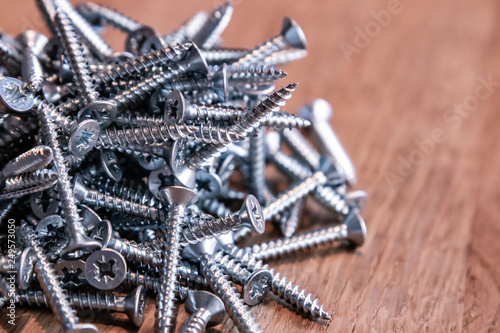 Many Screws in a mess on a wooden table