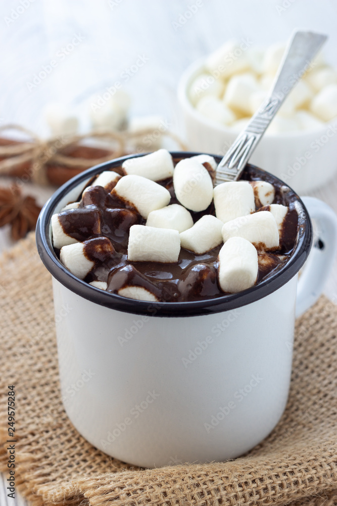 Hot chocolate with marshmallows in a white metal vintage mug Hot chocolate with marshmallows in a white metal vintage mug