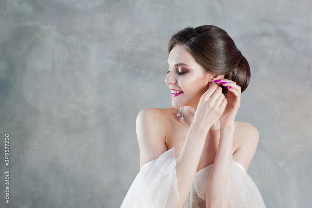 Beautiful and stylish bride in wedding dress in Studio on grey Beautiful and stylish bride in wedding dress in Studio on grey