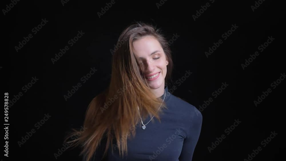 Portrait of young and slim brunette caucasian girl shaking her hair and dancing on black background. Portrait of young and slim brunette caucasian girl shaking her hair and dancing on black background.