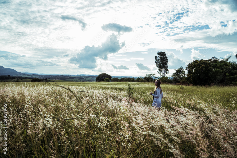 Fototapeta premium young woman having fun at sunset on a green grassy field