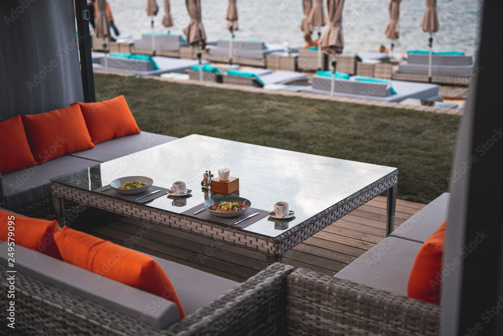 Obraz premium Comfortable terrace at the seaside with breakfast on the table