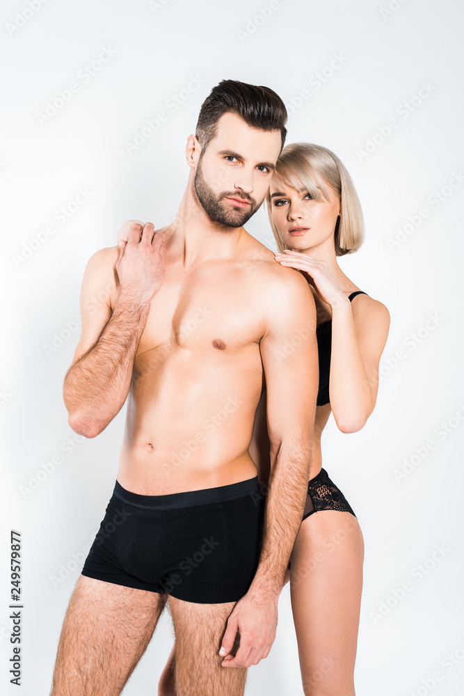 attractive couple in black underwear hugging isolated on grey attractive couple in black underwear hugging isolated on grey