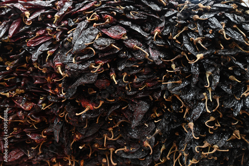 Stacked dried whole Guajillo chili peppers photo