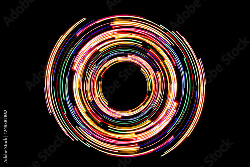 Abstract neon circle lines with empty copy space inside isolated on black background. Colorful led lights long exposure rotation photo.