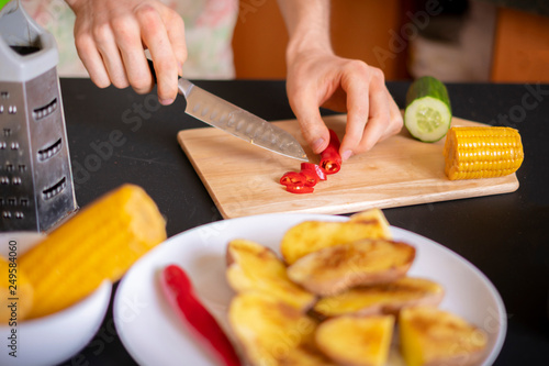 cooks hands slicing hot chilli pepper b