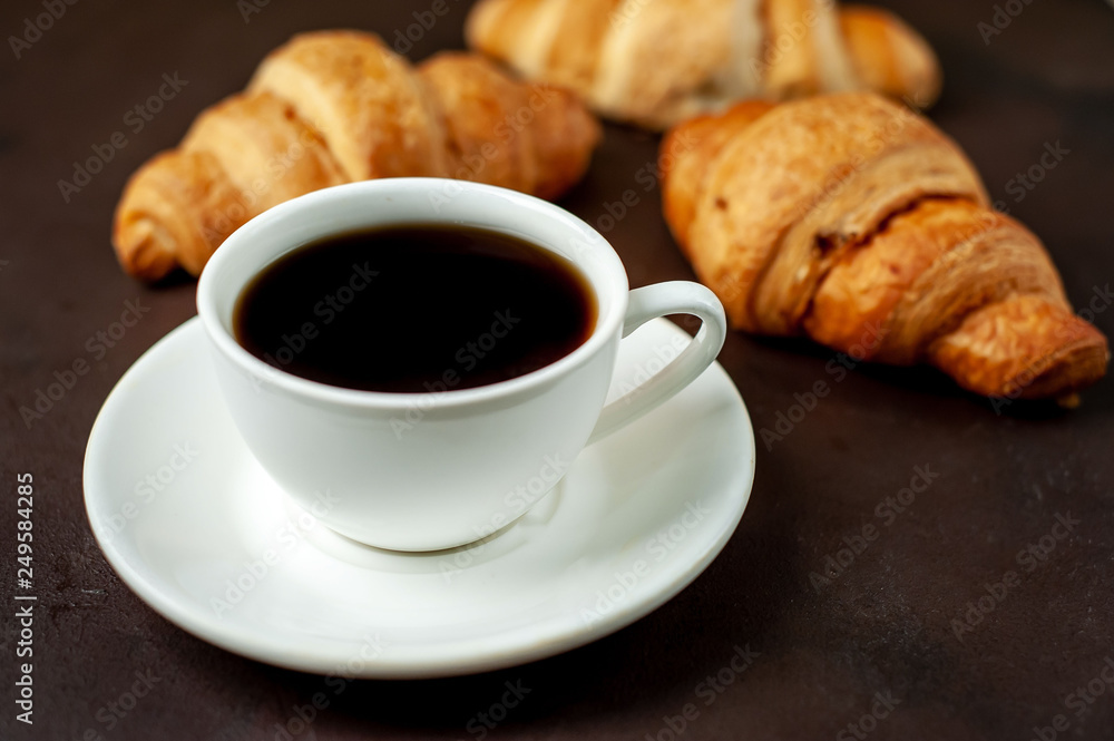 coffee and croissants on wooden cutting board, on the background concrete coffee and croissants on wooden cutting board, on the background concrete