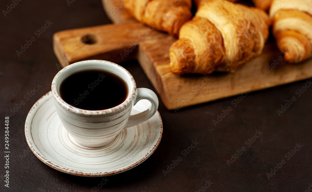 coffee and croissants on wooden cutting board, on the background concrete coffee and croissants on wooden cutting board, on the background concrete