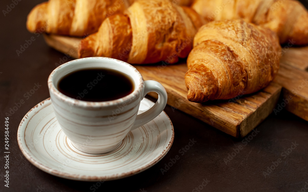 coffee and croissants on wooden cutting board, on the background concrete coffee and croissants on wooden cutting board, on the background concrete