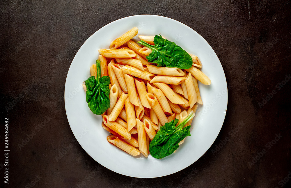 Penne pasta in tomato sauce on concrete background Penne pasta in tomato sauce on concrete background