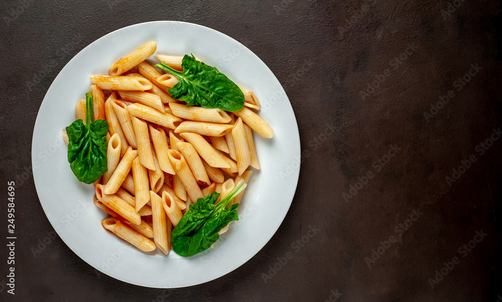 Penne pasta in tomato sauce on concrete background Penne pasta in tomato sauce on concrete background