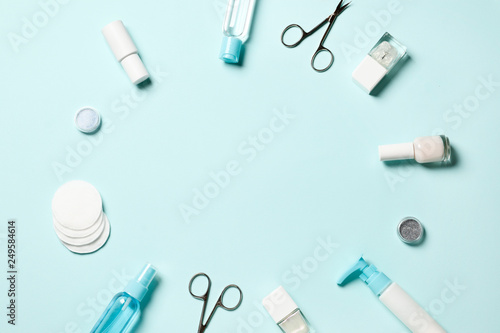 Composition of manicure tools and cosmetics and nail polishes on a blue background. Place for text.