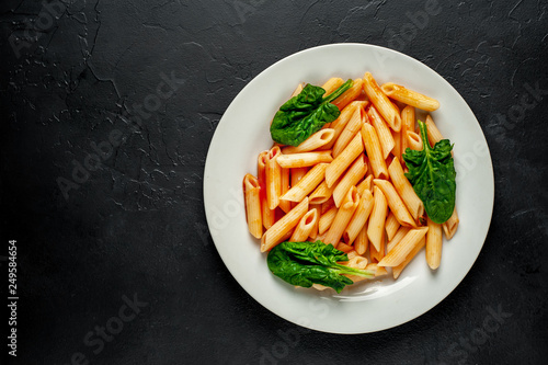Penne pasta in tomato sauce on concrete background