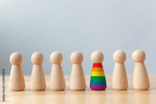 Human rights of LGBT campaign concept. Wooden dolls with rainbow colors are different stand out from crowd