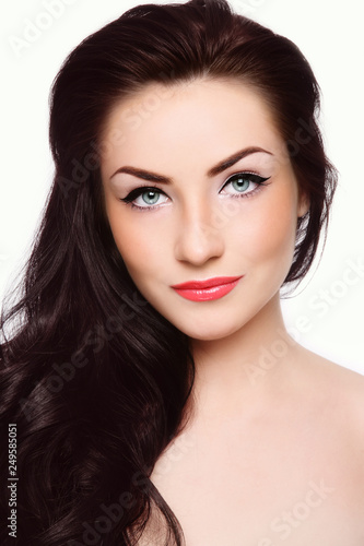 Portrait of young beautiful woman with long dark hair and cat eye make-up