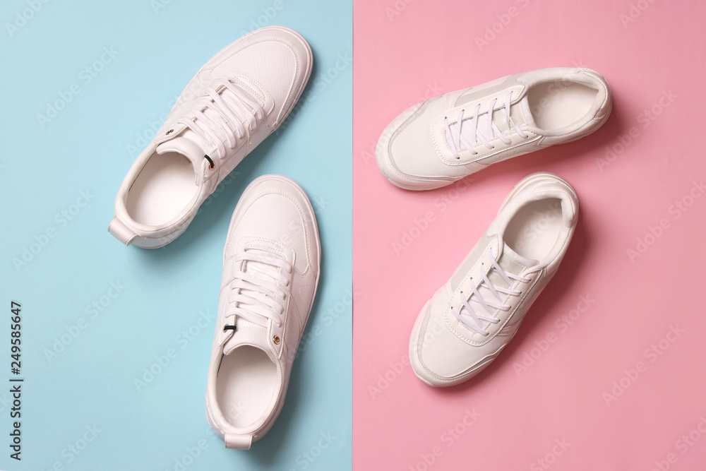Men's and women's sneakers on a colored background top view. Sport shoes. White running shoes Men's and women's sneakers on a colored background top view. Sport shoes. White running shoes