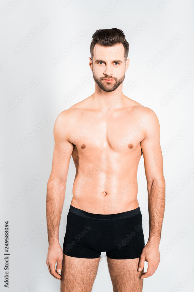 handsome bearded man posing in boxer shorts isolated on grey