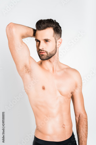 handsome shirtless young man posing isolated on grey