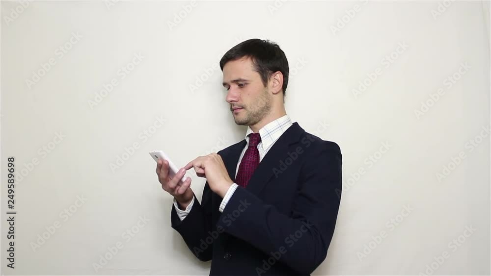 Young handsome businessman leafing through news feed on his smartphone. Portrait on white background Young handsome businessman leafing through news feed on his smartphone. Portrait on white background