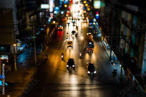 Night traffic in Bangkok. Street in the city center filled with cars passenger buses bikes and taxis. Night city lights up.