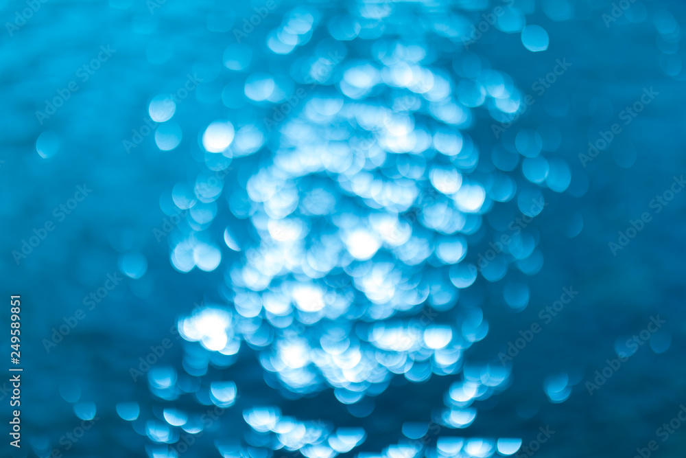 abstract blue background with bokeh lights. Defocused or blurred blue water background.