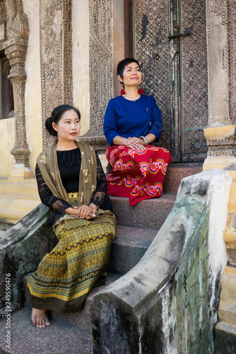 Deux femme Thaïe en habit traditionnel sur les marches d'un petit temple de Chiang Maï photo