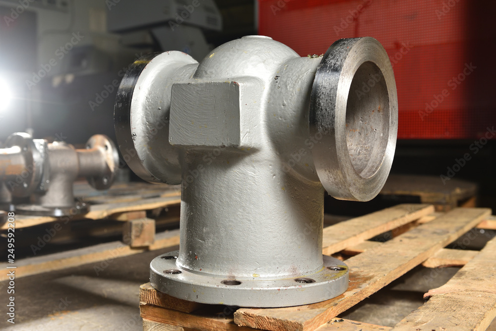 Gray metal pipes, bases for making valves, lie on a wooden panel before further processing on a milling machine. Base for creating valves in a factory Gray metal pipes, bases for making valves, lie on a wooden panel before further processing on a milling machine. Base for creating valves in a factory
