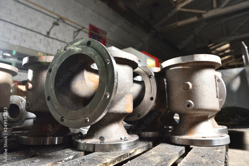 Factory production of taps and valves for water and gas. The base of the valves lie on a wooden