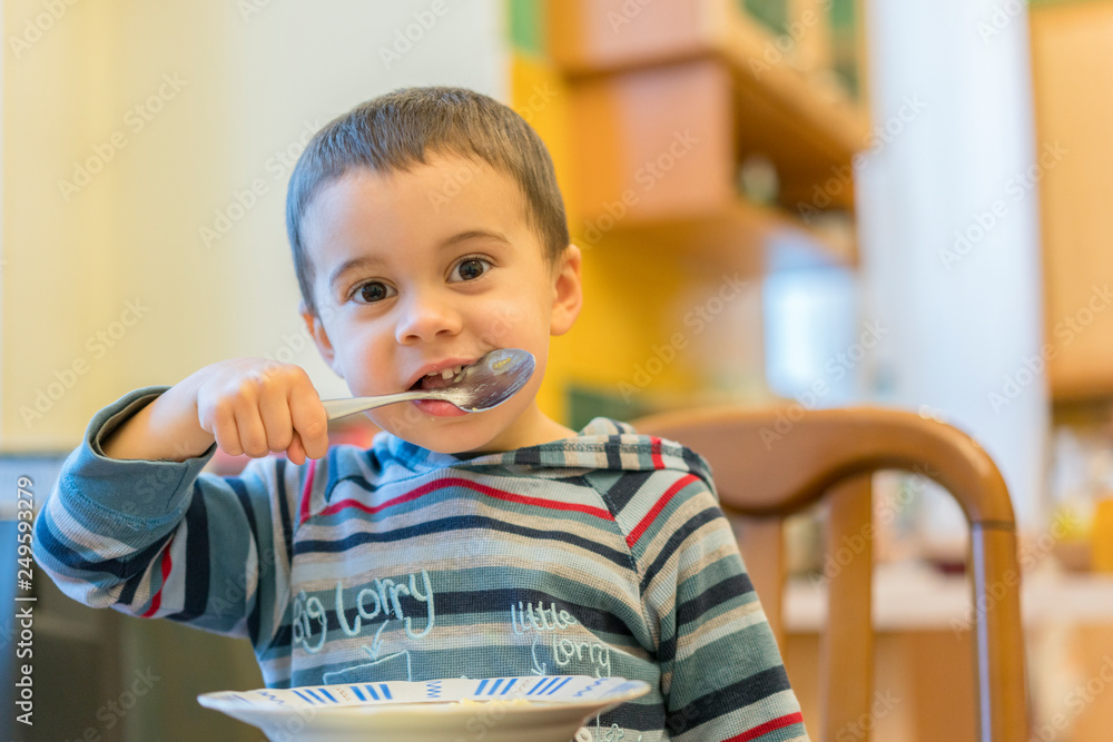 Funny baby eating porridge. Happy infant baby boy spoon eats itself. Funny baby eating porridge. Happy infant baby boy spoon eats itself.