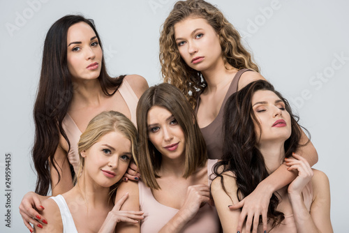 beautiful young women support each other isolated on grey