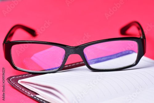 Items freelancer on a red background. Glasses and notebook