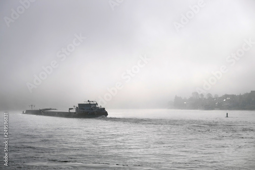 Frachtschiff auf dem Rhein im Nebel - Stockfoto