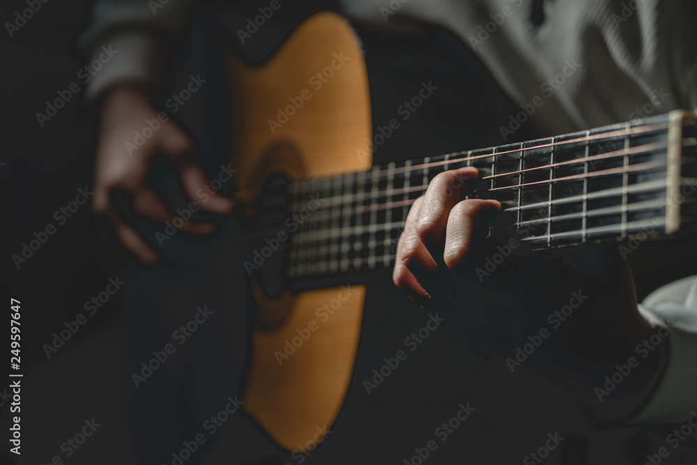 Close up on midsection of man Playing a guitar 