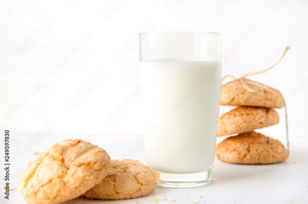 milk in a glass, some cookies on a white background milk in a glass, some cookies on a white background