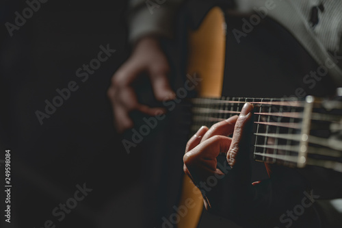Close up on midsection of man Playing a guitar 