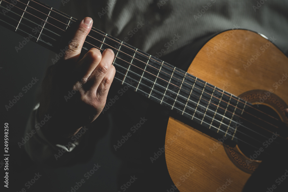 Fototapeta premium Close up on midsection of man Playing a guitar 