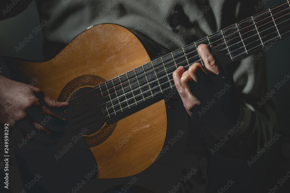Fototapeta premium Close up on midsection of man Playing a guitar 