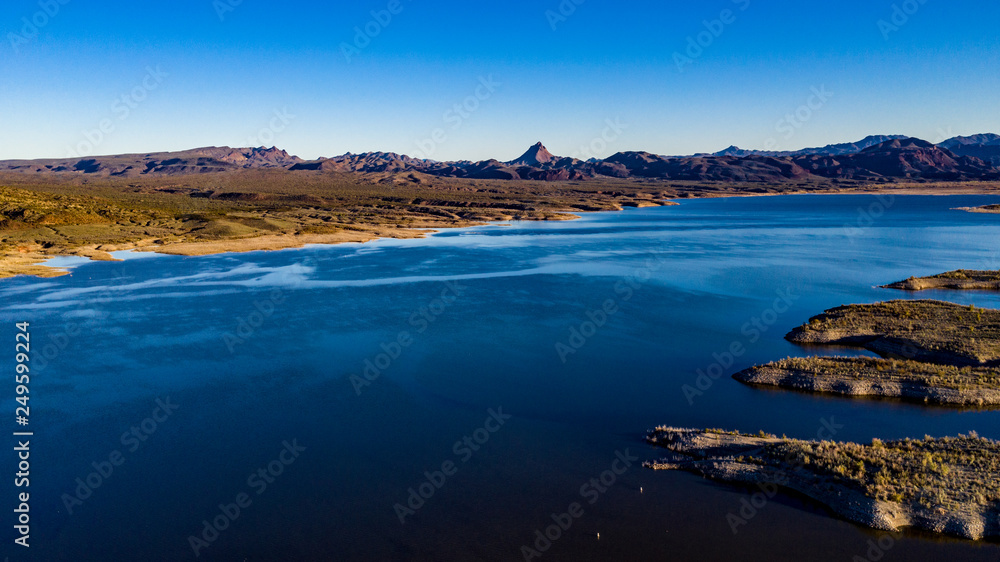 Fototapeta premium Aerial, drone view of Alamo Lake, Arizona in the remote desert near Wenden with vivid blue water and sky with Alamo Dam