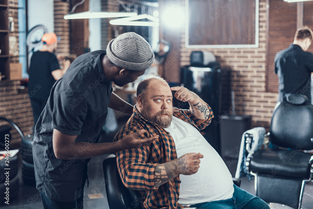 Man in salon pointing on his hair cut
