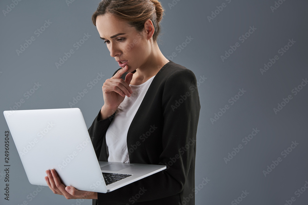 Pretty woman looking at laptop display with worried face Pretty woman looking at laptop display with worried face