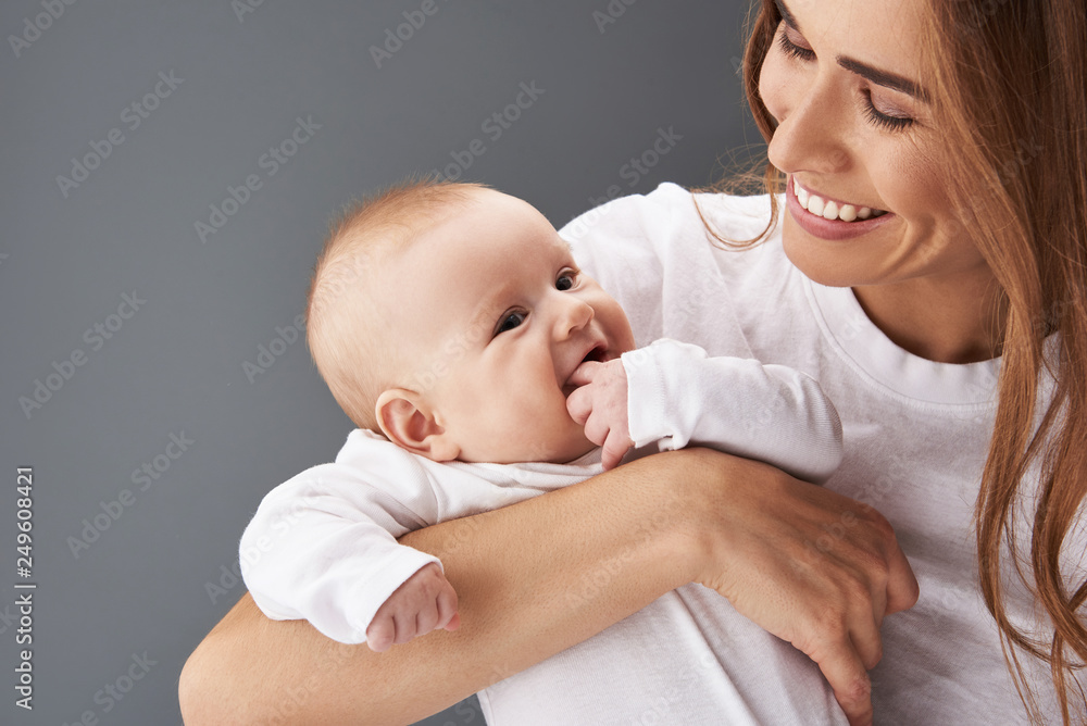 Gorgeous lady looking at her new born baby with smile - obrazy, fototapety, plakaty 