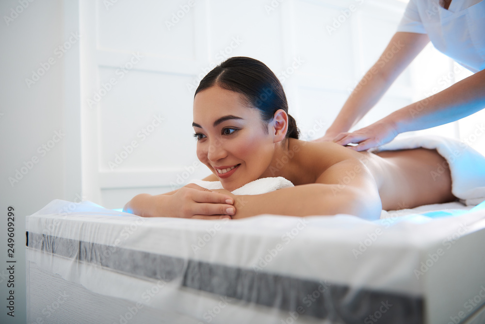 Smiling asian lady have relaxing massage of back Smiling asian lady have relaxing massage of back