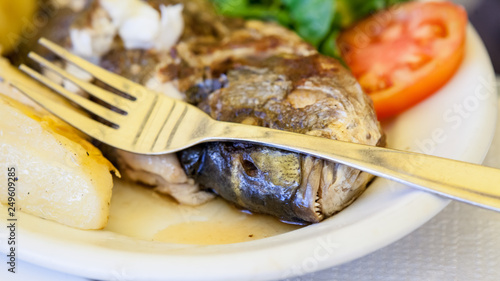 Grilled sea bream with poatatoes, tomatoes and lemon photo