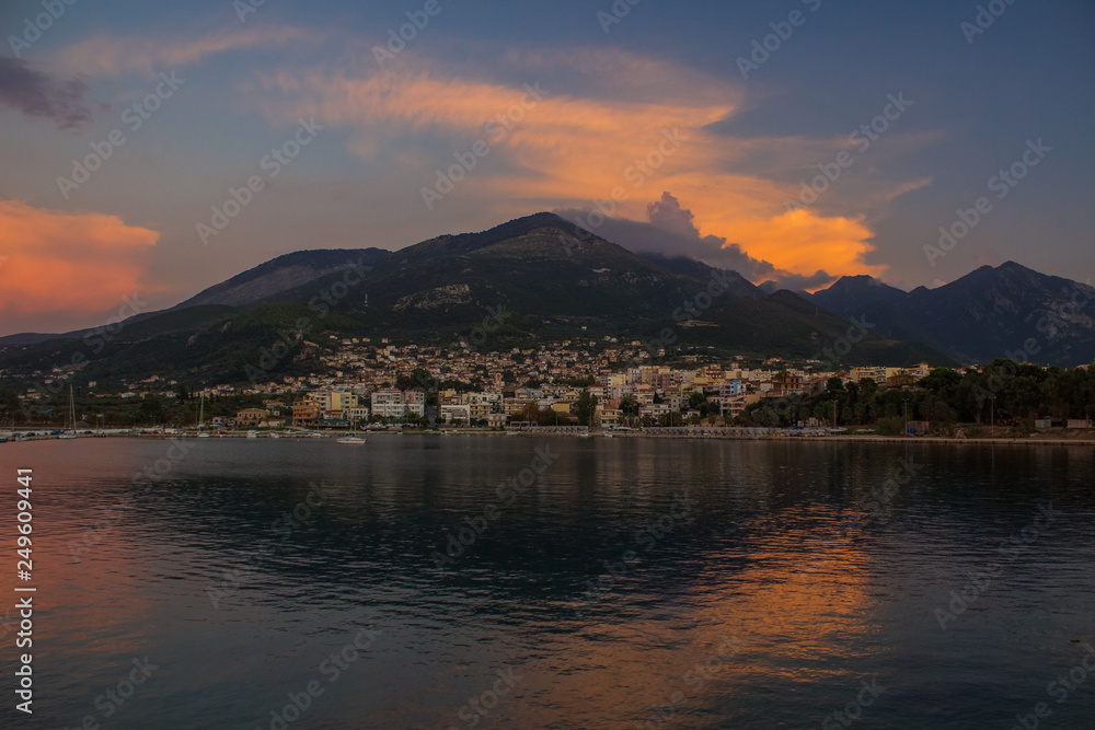 South Europe landscape soft focus view of small city near sea on lonely mountain background in evening twilight time after sunset 