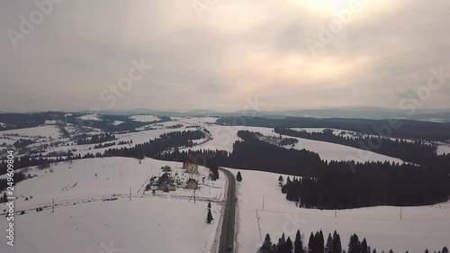 Aerial rural view of road passing to horizon. Winter travel. Snowy mountain landscapein early spring. Carpathian mountains in Ukraine. Beskidy range in Poland photo
