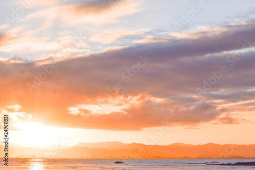 The pale sunset colors the beach scene below in Gisborne  New Zealand.