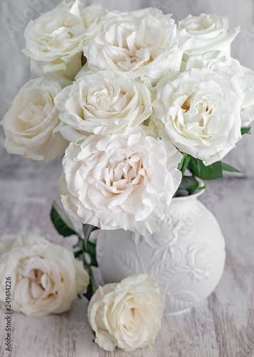 Beautiful fresh roses in a vase on a table . light background