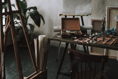Table with artistic tools and easel on the left side