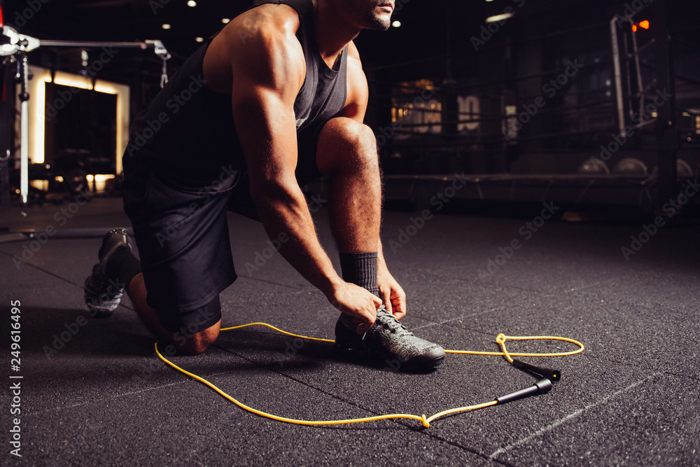 Man stretching up and getting ready to powerful workout on jump rope in  boxing sport gym Stock Photo